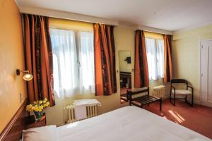 A bed or beds in a room at Hôtel Beauséjour