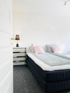 um quarto com uma cama com almofadas cor-de-rosa em Scandinavian Apartment Hotel - Tobaksgården - 2 room apartment em Horsens