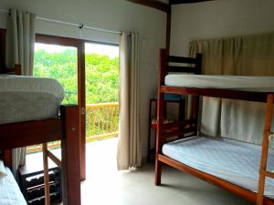 a room with three bunk beds and a balcony at Casa da Ponte, Trindade in Trindade