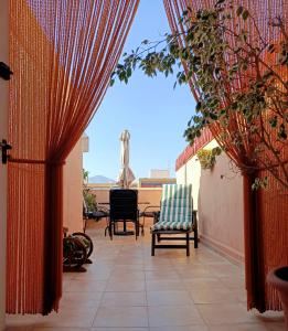 een patio met een rood gordijn en stoelen bij Exclusive Penthouse Pool & Beach - Lovely for families - Los Pinos Residential in El Campello