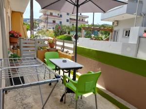 un tavolo con sedie e un ombrellone su un balcone di Kissamos Nice Apartment1 a Kíssamos