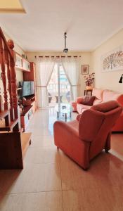 een woonkamer met een rode bank en een televisie bij Exclusive Penthouse Pool & Beach - Lovely for families - Los Pinos Residential in El Campello