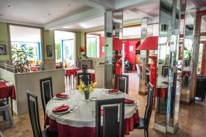 a dining room with a table and chairs at Hôtel Beauséjour in Chaudes-Aigues