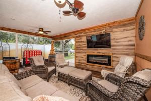 a living room with a couch and chairs and a fireplace at Gulfport Beach Vacation Rental in St. Petersburg