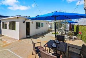 a patio with a table and a blue umbrella at Huge Studio - 7min LAX 405 SoFi in Hawthorne