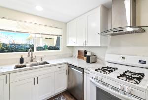 uma cozinha branca com um fogão e um lavatório em Huge Studio - 7min LAX 405 SoFi em Hawthorne