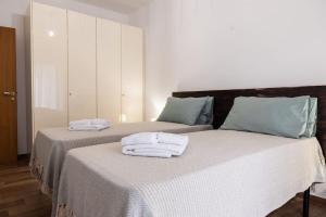 - 2 lits avec serviettes dans une chambre dans l'établissement Da Zietta casa dal sapore tipico, à Castellana Grotte