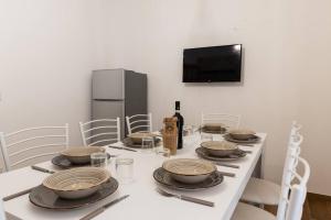 - une table blanche avec des assiettes et une bouteille de vin dans l'établissement Da Zietta casa dal sapore tipico, à Castellana Grotte
