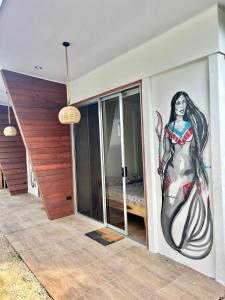 a mural of a woman on the wall of a bedroom at Apartamentos en el Centro de Puerto Viejo in Puerto Limón