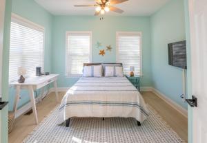 ein blaues Schlafzimmer mit einem Bett und einem Schreibtisch in der Unterkunft The Starfish Cove in Carolina Beach