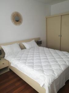 uma grande cama branca num quarto com um espelho em Mamaia Nord Apartament em Mamaia