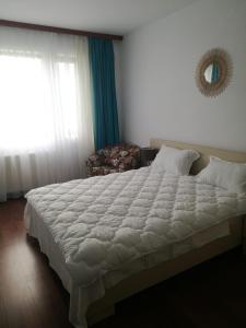 um quarto com uma grande cama branca e uma janela em Mamaia Nord Apartament em Mamaia