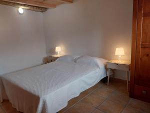 ein Schlafzimmer mit einem Bett und zwei Tischen mit Lampen in der Unterkunft Casa Algarvia G&S in Luz de Tavira