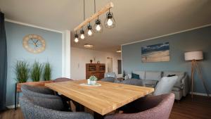 a dining room with a wooden table and chairs at Seeblick - 4-Zimmer Wohnung in Immenstaad am Bodensee