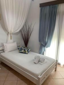 een bed in een kamer met een raam met gordijnen bij Mary's apartment in Stómion