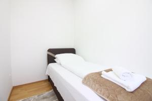 een slaapkamer met een bed met witte lakens en handdoeken bij Apartment Roma at Bascarsija in Sarajevo