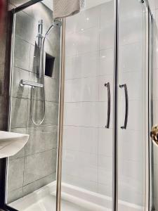 um chuveiro com uma porta de vidro na casa de banho em The Diamond Inn em Ponteland