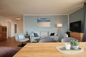 a living room with a table and chairs and a couch at Seeblick - 4-Zimmer Wohnung in Immenstaad am Bodensee