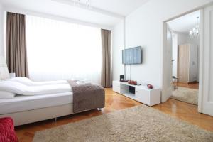 een witte slaapkamer met een groot bed en een spiegel bij Apartment Roma at Bascarsija in Sarajevo