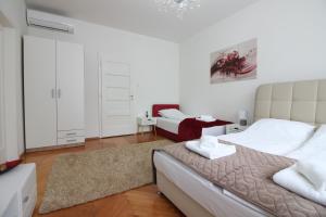 een witte slaapkamer met een groot bed en een bank bij Apartment Roma at Bascarsija in Sarajevo
