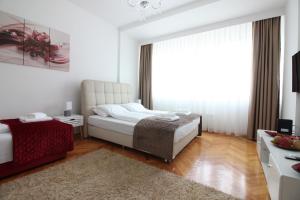 een slaapkamer met 2 bedden en een groot raam bij Apartment Roma at Bascarsija in Sarajevo