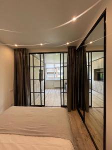 1 dormitorio con 1 cama y puertas correderas de cristal en Residential complex Parkland en Kiev