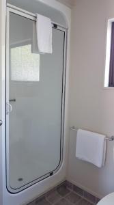 a bathroom with a shower with a glass door at 88 Wallace Court Motel in Wellington