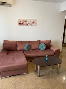 uma sala de estar com um sofá castanho e uma mesa em Mamaia Nord Apartament em Mamaia