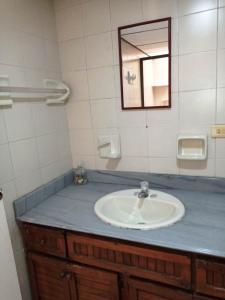 W łazience znajduje się umywalka i lustro. w obiekcie Yellow House Hostel w mieście Medellín