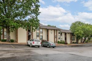 ein Gebäude mit zwei Autos auf einem Parkplatz in der Unterkunft Pointe Royale Condo Retreat in Branson in Branson