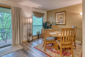 una sala da pranzo con tavolo, sedie e televisione di Pointe Royale Condo Retreat in Branson a Branson