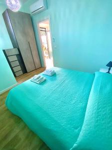 Una cama azul con dos toallas encima. en Bilocale Nucarella, en Scilla