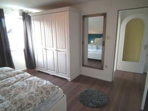 a bedroom with a bed and a large mirror at Ferienwohnung Das Inge die Oberne in Bernau in Bernau am Chiemsee