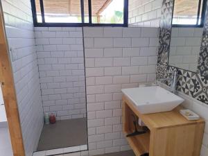 ein weißes Badezimmer mit einem Waschbecken und einem Spiegel in der Unterkunft Colibri 1 Votre séjour chez Stéphanie et David in Playa Grande