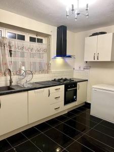 a kitchen with white cabinets and a stove top oven at 2 Bedroom Flat in Vauxhall, London in London