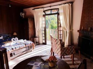 a bedroom with a bed and a glass door at Pousada Lua e Sol in Santo Antônio do Pinhal