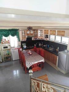 a kitchen with a table with red chairs and a kitchen with at Room in Lobo Triple N Home stay 1st N in Lobo