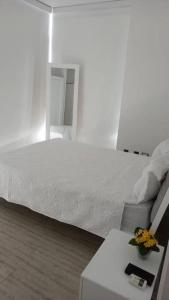 a bedroom with a bed and a table with flowers on it at Comfy Apartment City Center - PH Quartier Atlapa in Panama City