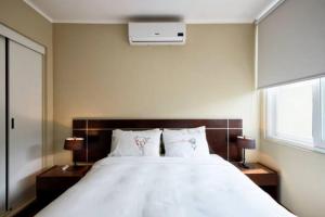 1 dormitorio con 1 cama blanca grande y 2 almohadas en Roma, en Lima
