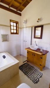 ein Badezimmer mit einem Waschbecken, einem WC und einer Badewanne in der Unterkunft Sitio Boa Fé - 300m das cachoeiras Moinho e Salomão in Carrancas