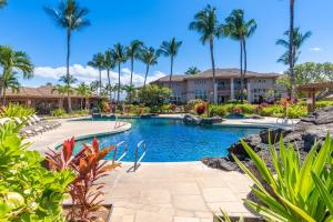 a pool at a resort with palm trees at Waikoloa Colony Villas 1703 in Waikoloa