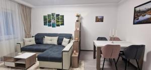 - un salon avec un canapé bleu et une table dans l'établissement All In Jacuzzi Apartment, à Petroşani