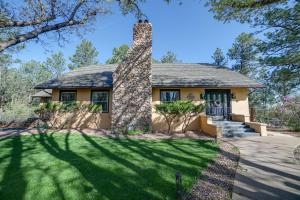 a house with a stone chimney in the yard at Inviting Colorado Springs House with Spacious Deck! in Colorado Springs
