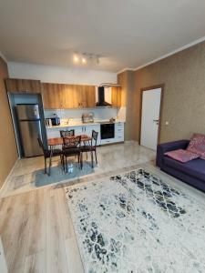 ein Wohnzimmer mit Sofa und Tisch in der Unterkunft 2 комнатная Нурсат ЖК Алтын Шанырак in Schymkent