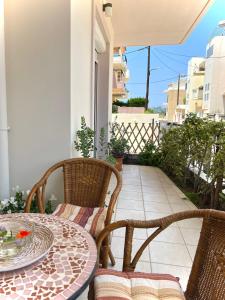 a patio with a table and chairs on a balcony at Haplotēs in Koskinou