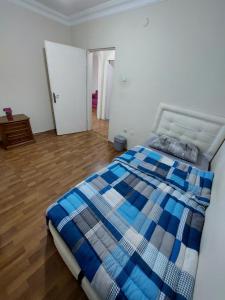 1 dormitorio con 1 cama con manta azul y blanca en B.A.A Sabiha Gökçen en Estambul