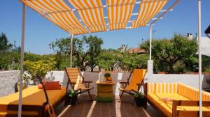 a patio with chairs and a table and an umbrella at Casa do Areal in Mira