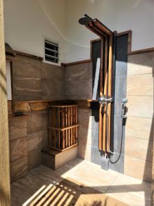 a shower in a bathroom with a wooden wall at Green Villa Moorea in Temae