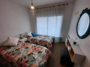 a bedroom with two beds and a mirror at DEPARTAMENTO a PASOS del CENTRO, BARRIO NORTE, 4 PERSONAS in La Plata
