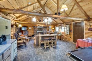 a kitchen and living room in a log cabin at Remote Escape Klamath Falls Cabin By Lake and Hikes in Klamath Falls